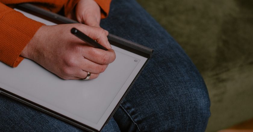 Hand die schrijft in notitieboek als manier om trauma na vreemdgaan van partner te verwerken